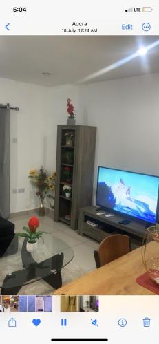 sala de estar con TV y mesa de cristal en City Views Apartment en Bawaleshi