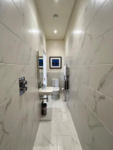 a white bathroom with a sink and a toilet at Beinn Mhor Lodge, 63 Culduthel Road in Inverness