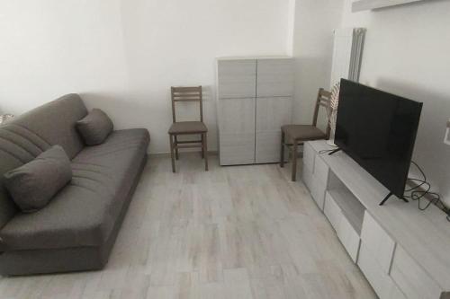 ein Wohnzimmer mit einem Sofa und einem Flachbild-TV in der Unterkunft Vico del Teatro in Formia
