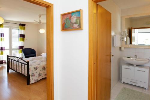 a bathroom with a bed and a sink in a room at Apartments Mel in Bol