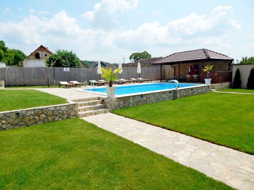 a backyard with a swimming pool and a house at Aqualux apartments in Vrdnik