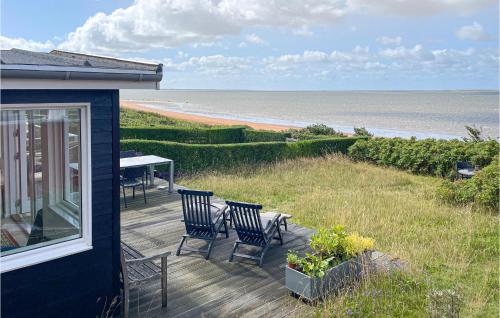a deck with chairs and a table and the beach at Awesome Home In Esbjerg V With Wifi in Esbjerg