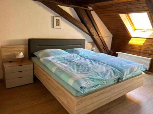 a bed with a blue comforter in a bedroom at Altstadtliebe in Bad Säckingen