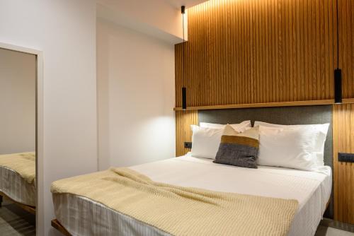 a bedroom with a large bed with a wooden headboard at Amare Studios in Agios Nikolaos