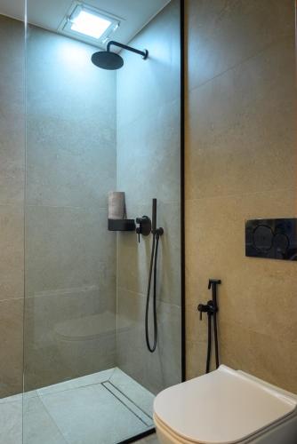 a bathroom with a glass shower with a toilet at Amare Studios in Agios Nikolaos