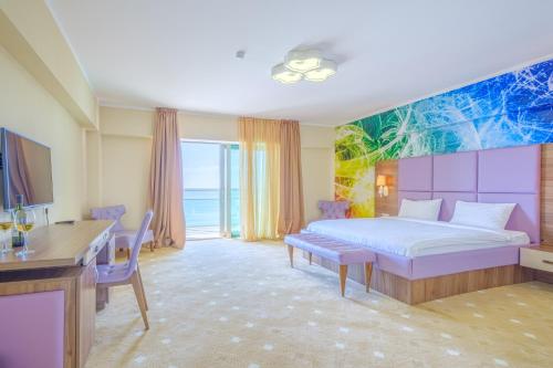 una camera con letto, tavolo e scrivania di Castello Mare All Inclusive Resort a Batumi