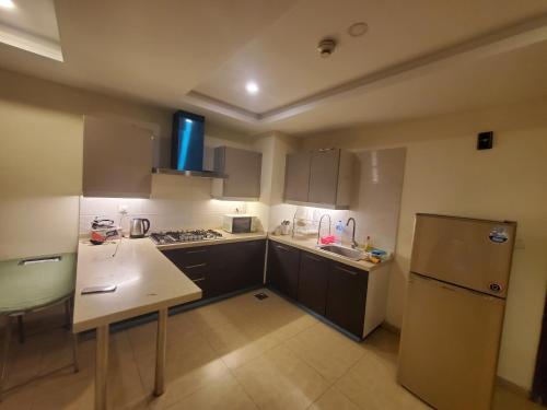 una pequeña cocina con nevera y fregadero en Private 1-Bedroom Apartment, en Rawalpindi