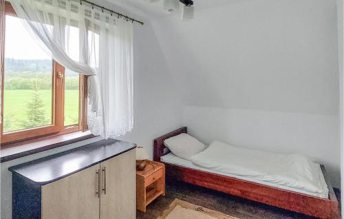 a small bedroom with a bed and a window at Awesome Home In Lesko With Kitchen in Lesko
