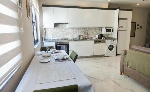 a kitchen with a table and a kitchen with white cabinets at Alanya City Tower sea&mountain view in Alanya