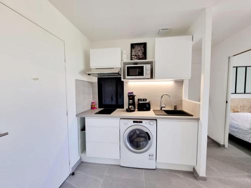 une cuisine avec un lave-linge et un micro-ondes dans l'établissement Appartement moderne et confort, à Palavas-les-Flots