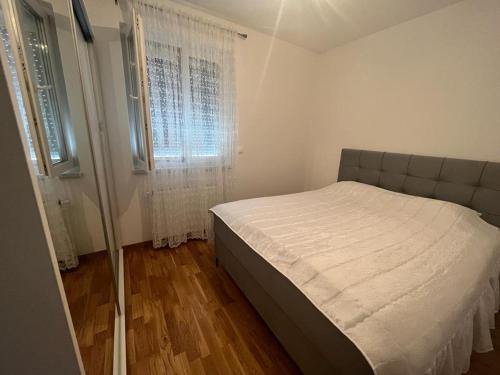 - une petite chambre avec un lit et une fenêtre dans l'établissement Apartman Sučić, à Livno