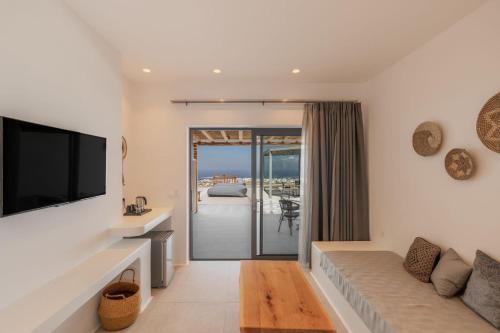 a living room with a couch and a flat screen tv at Sunset Hill Suites in Mýkonos City
