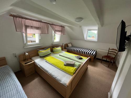 1 dormitorio pequeño con 1 cama y 1 sofá en Pension Alpenrose, en Bad Schandau