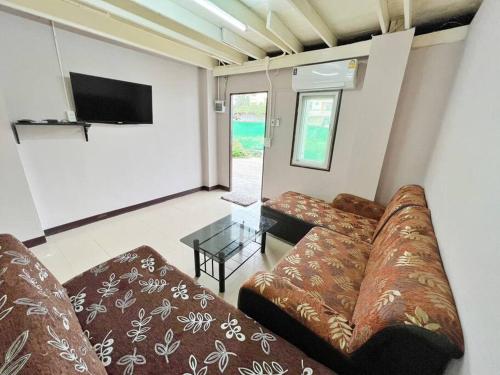 a living room with a couch and a glass table at บ้านเช่า Wilai Townhome Udon in Udon Thani