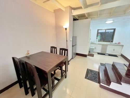 uma sala de jantar com uma mesa de madeira e cadeiras em บ้านเช่า Wilai Townhome Udon em Udon Thani