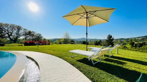 a couple of chairs and an umbrella next to a pool at Agromarino in Sirolo
