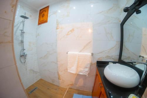 La salle de bains est pourvue d'un lavabo et d'une douche. dans l'établissement Abdessamad Appartement 2, à Essaouira