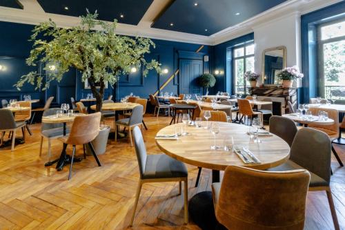 a restaurant with tables and chairs in a room with blue walls at Hôtel Gallia in Aix-les-Bains