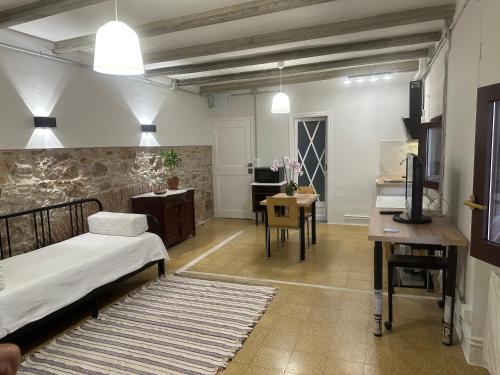 a bedroom with a bed and a desk and a television at NOTARIA-Apartamento y Estudio en casco antiguo, al lado de playa, Rambla y Monasterio, con acceso a terraza ajardinada in Sant Feliu de Guixols