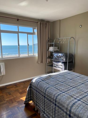 Schlafzimmer mit einem Bett und Meerblick in der Unterkunft Apartamento frente para o mar in Balneário Camboriú