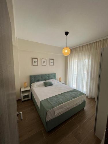 a bedroom with a large bed and a chandelier at Sea Shell in Nikiti