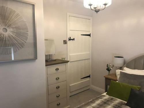 een slaapkamer met een bed, een dressoir en een spiegel bij Boutique style cottage Bridgnorth in Bridgnorth