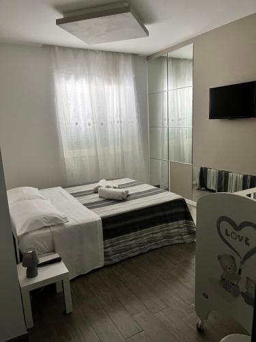 1 dormitorio con 1 cama y TV en una habitación en L’arcobaleno, en Valmontone