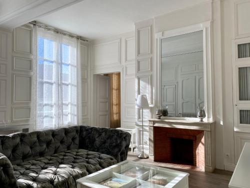 a living room with a couch and a fireplace at Hôtel Particulier de Champrond in Chartres