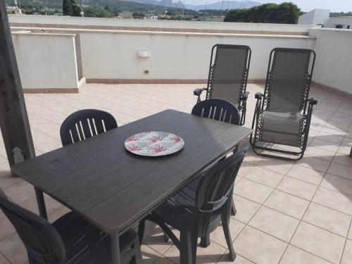 een houten tafel en stoelen op een patio bij Relax Apartment in San Vito in San Vito lo Capo