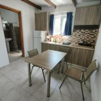 a kitchen with a wooden table and chairs in it at Vine Veranda in Palaiochora