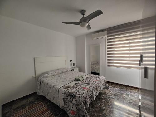 1 dormitorio con 1 cama y ventilador de techo en Vivienda en el centro histórico con ascensor, en Jaén