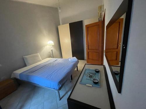 a bedroom with a bed and a table and a mirror at Appartamento al mare in Bosa Marina