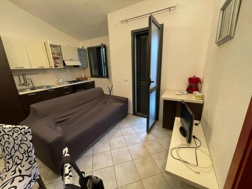 a small room with a bed and a kitchen at Appartamento al mare in Bosa Marina