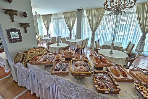 a table with many different types of bread and pastries at Hotel Firenze in Serra Negra