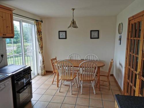 a kitchen with a table and chairs in a kitchen at The Cobbler Rosscarbery Holiday Cottage in Rosscarbery