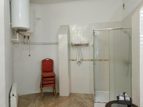 um chuveiro com uma cadeira vermelha na casa de banho em Villa5floors em Chisinau