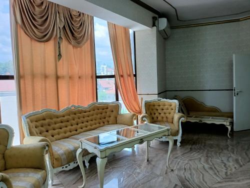 uma sala de estar com sofás, uma mesa e uma janela em Villa5floors em Chisinau