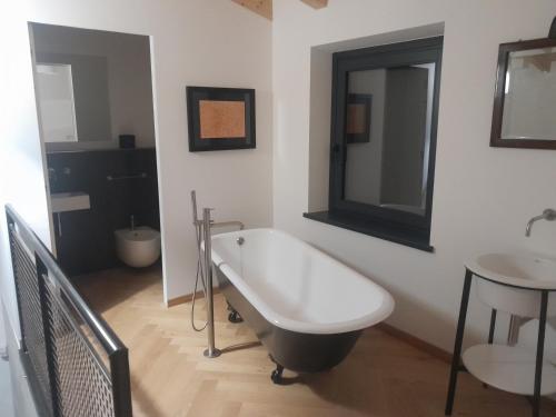 uma casa de banho com uma banheira e um lavatório em CA' DE BERTO em Valcarecce