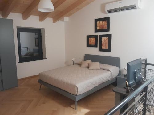 ein Schlafzimmer mit einem Bett und einem TV in der Unterkunft CA' DE BERTO in Valcarecce
