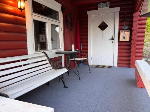 a porch of a red house with a table and a door at Cozy and spacious cabin in Svensby