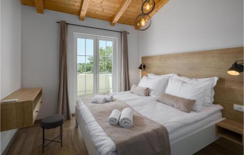 a bedroom with a large white bed with towels on it at 3 Bedroom Cozy Home In Buje in Buje