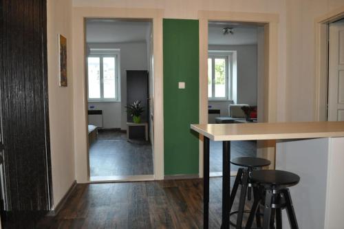 a living room with a green accent wall and stools at Apartment in Praha 3 in Prague