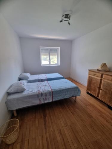 een slaapkamer met een bed en een houten vloer bij Chez Lofred 2 in Four
