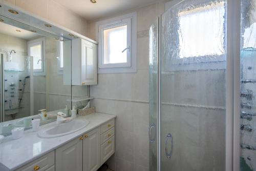 La salle de bains est pourvue d'un lavabo et d'une douche. dans l'établissement La Champanel Maison vue Mer JO24, à Marseille