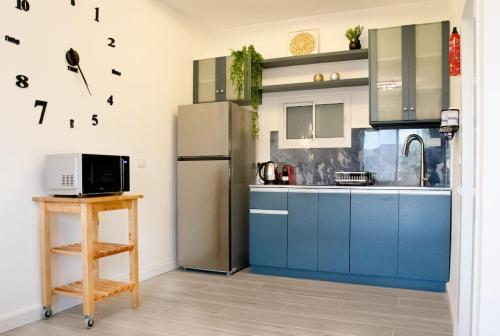 een keuken met blauwe kasten en een koelkast bij הבית ליד הבוסתן in Mikhmannim