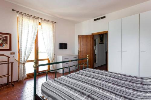 sypialnia z łóżkiem i dużym oknem w obiekcie Casa Velio w mieście Castiglione della Pescaia