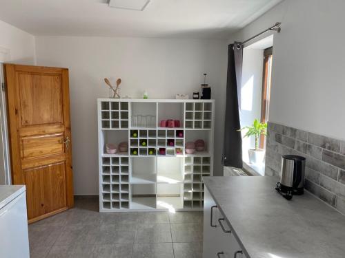 a kitchen with a white shelving unit in a room at Ferienwohnung sentio-comfortable Saalfeld in Saalfeld