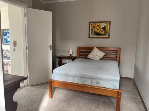 a bedroom with a bed with a wooden head board at Linda Cobertura na Passagem in Cabo Frio