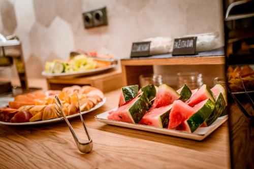 a table with plates of watermelon sandwiches and other foods at Penzion Včelařský Dvůr in Lednice