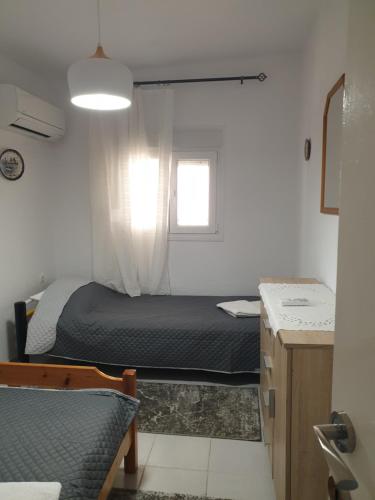 a small bedroom with a bed and a window at VILLA ARHONTIKO in Asprovalta